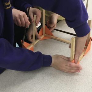Children working together to assemble a frame